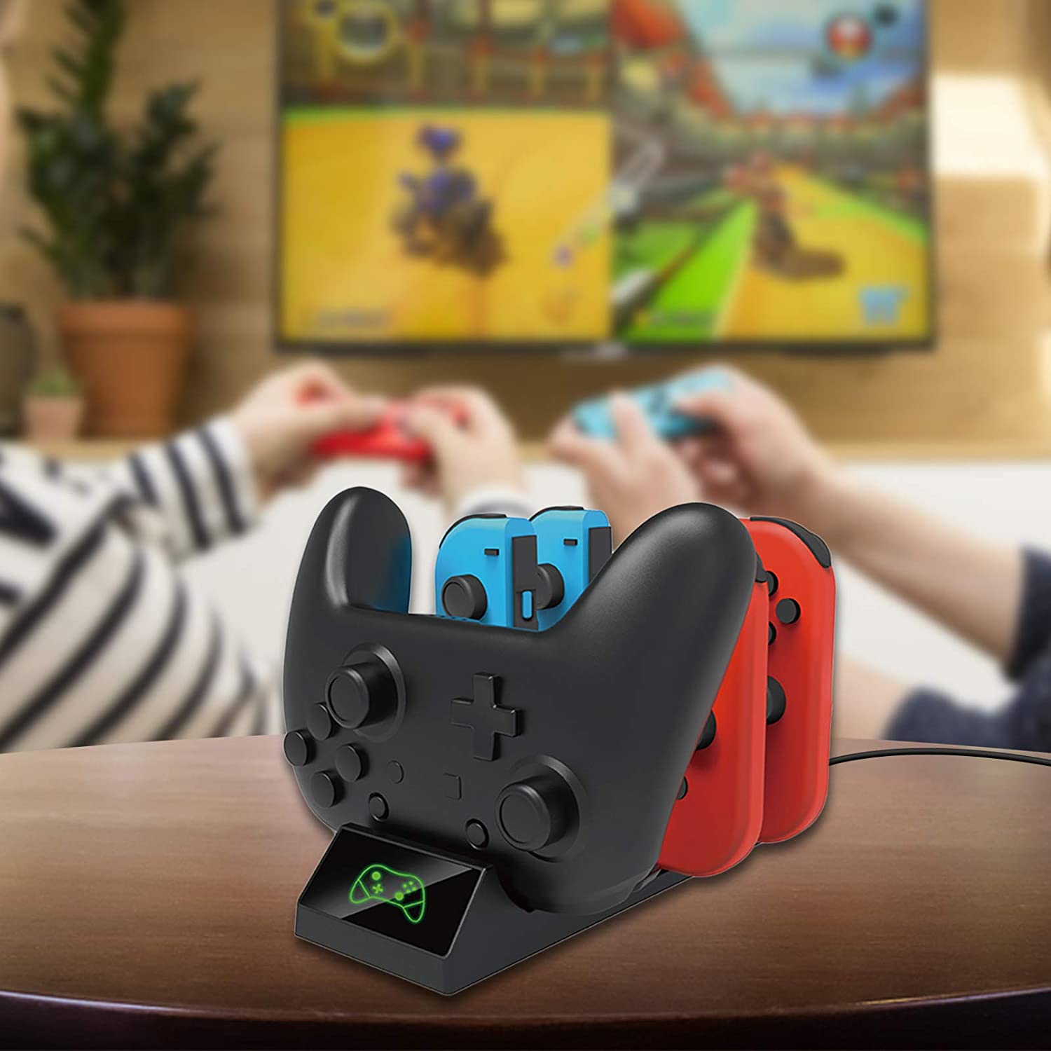 The dock is placed on the table and is charging one controller and two pairs of Joycons.
