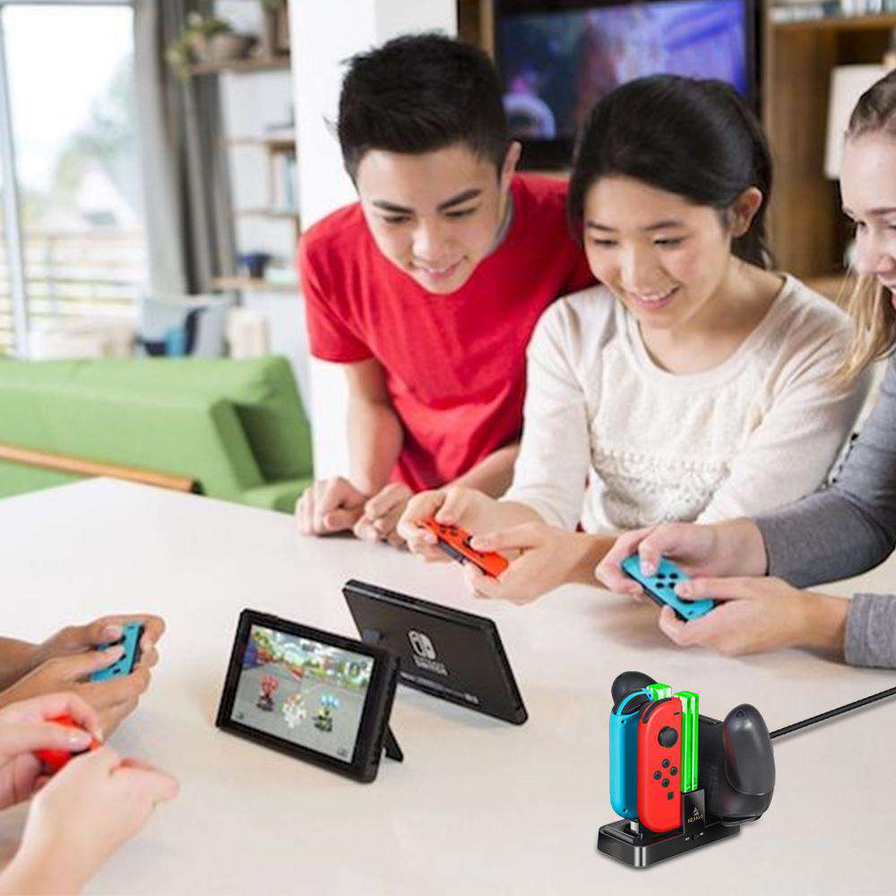 A group of young people playing Switch games with a charging dock nearby.